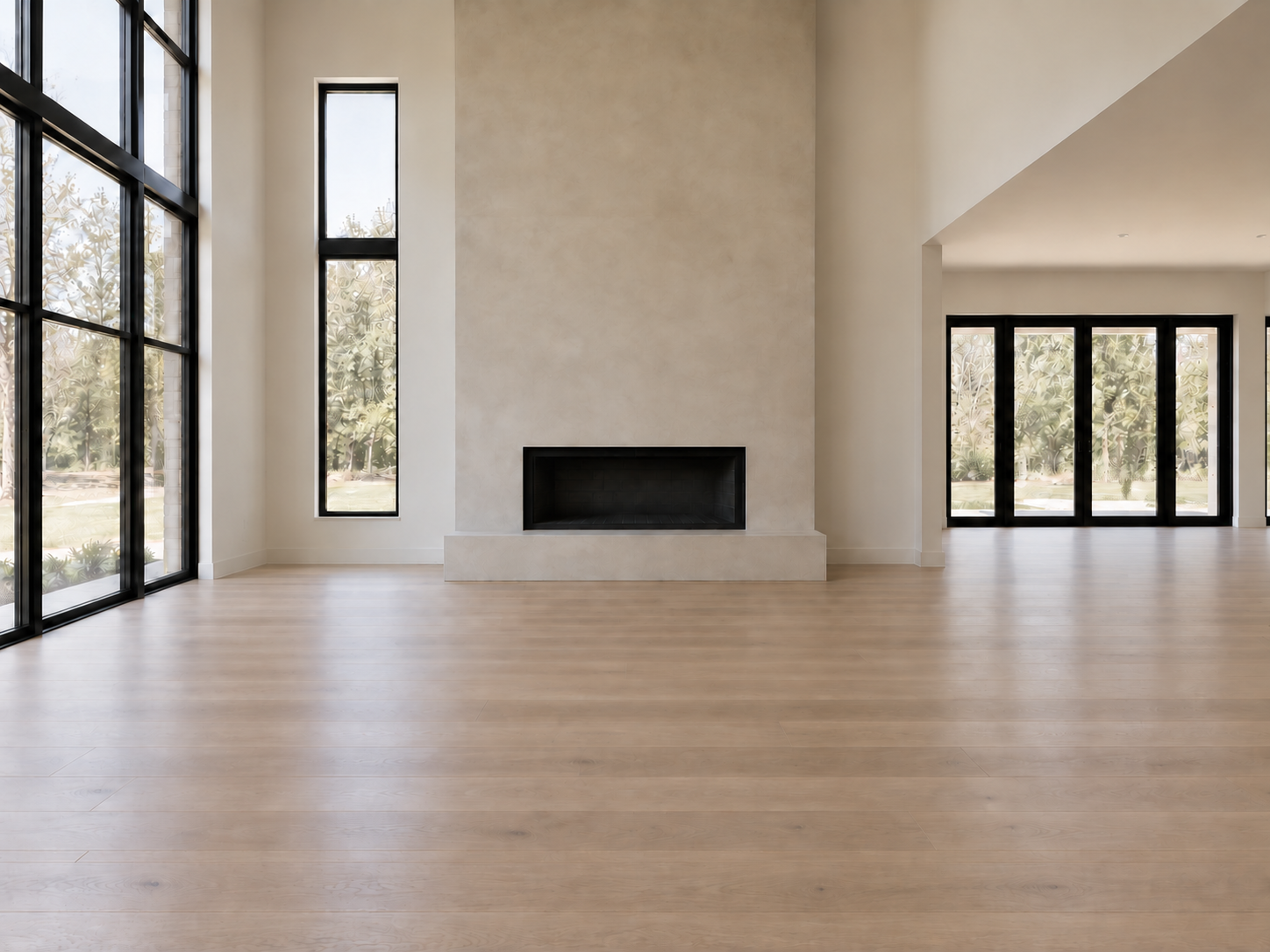 Unfurnished great room after the remodel with a plaster fireplace wall, black-framed windows, and light oak flooring